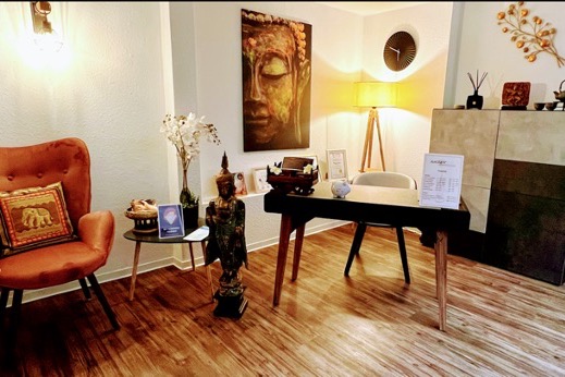 Sitzecke im Studio mit Sessel, Buddha-Bild und Schreibtisch
